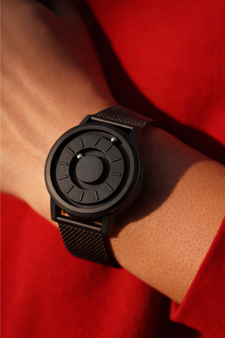 Black watch on a wrist with a red background