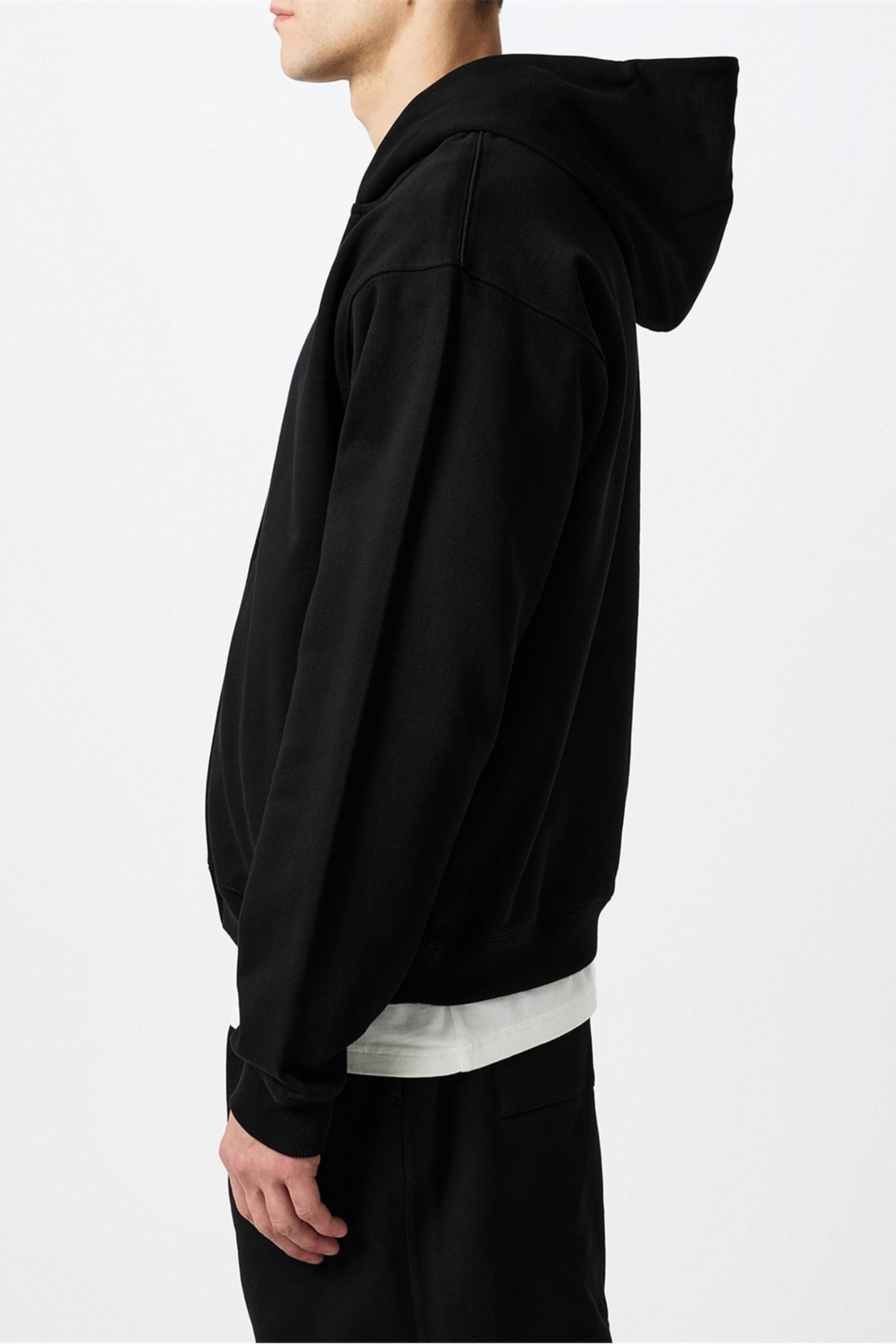 Person wearing a black hoodie and black pants.