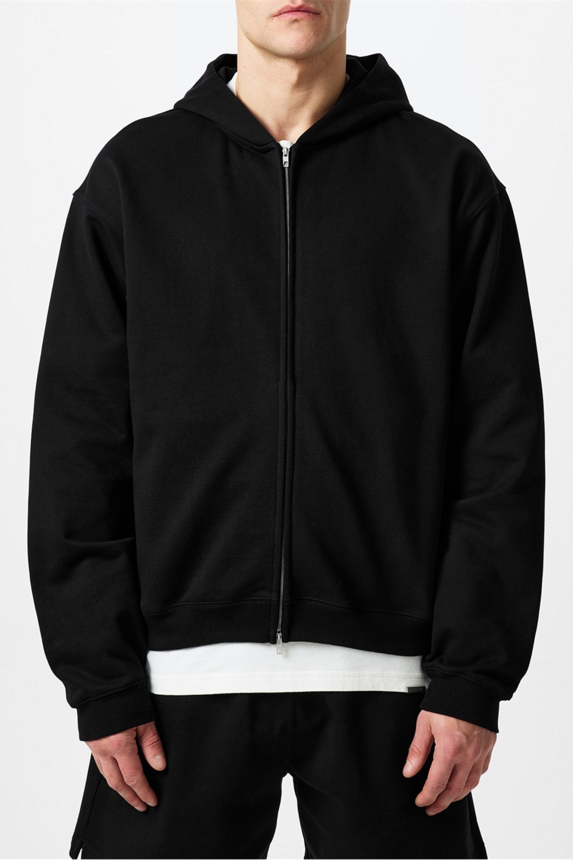 A person wearing a black zip-up hoodie.