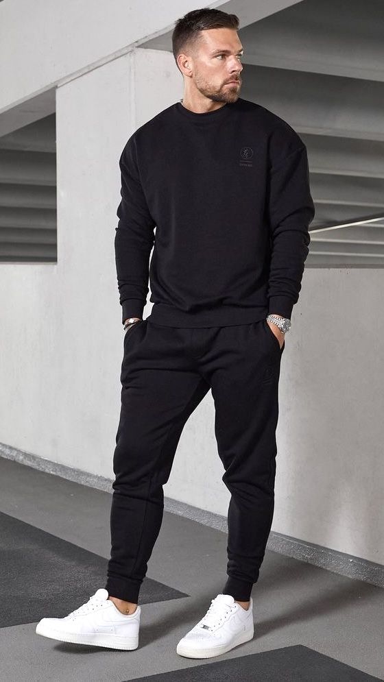 Man wearing a black cargos with white sneakers in an urban setting