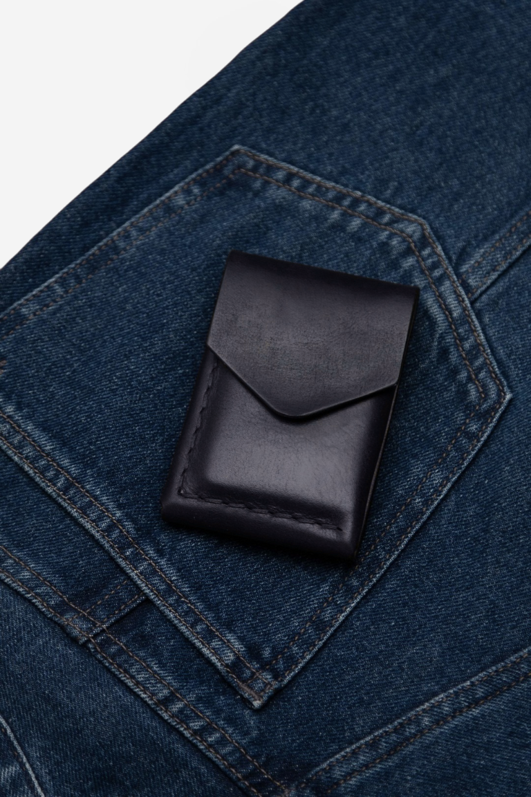 Black wallet for men on a blue denim pocket