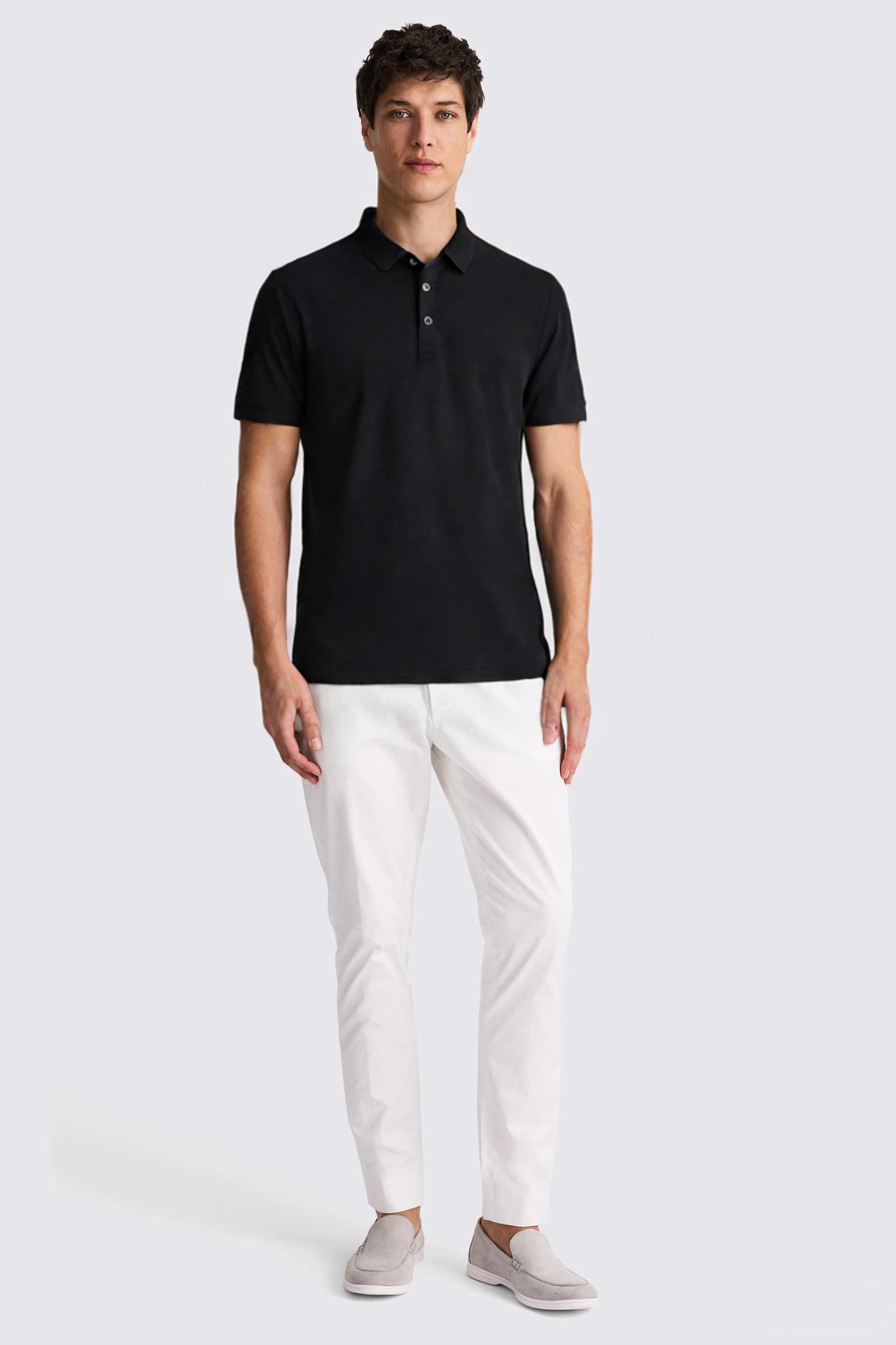 Man standing, black polo shirt, white pants, gray loafers.
