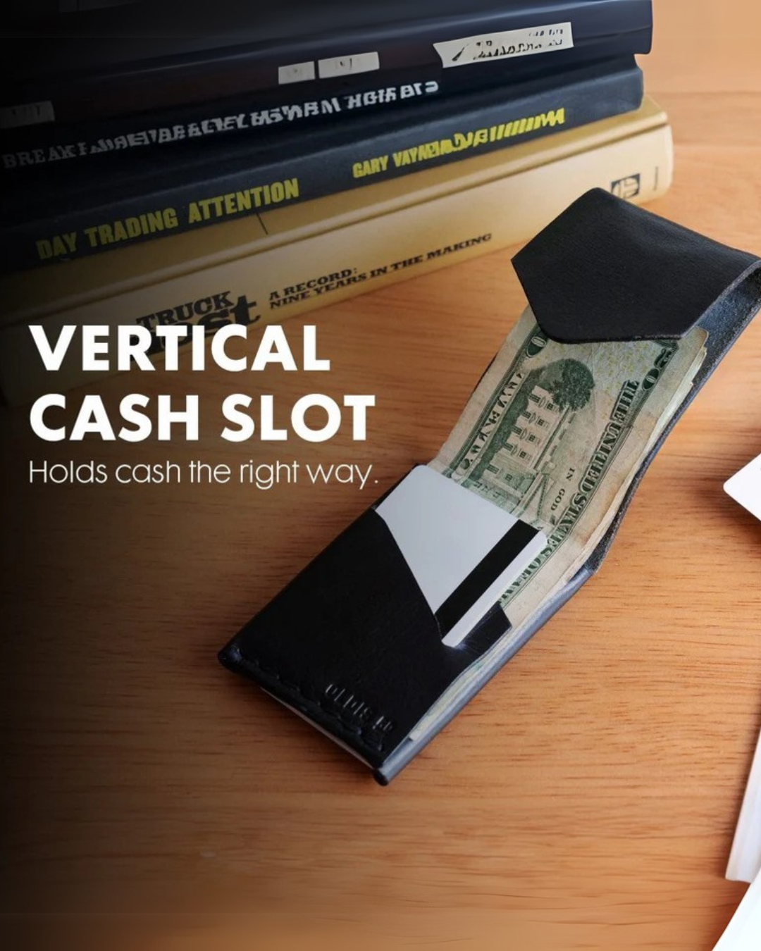 Black wallet with a vertical cash slot on a wooden surface with books.