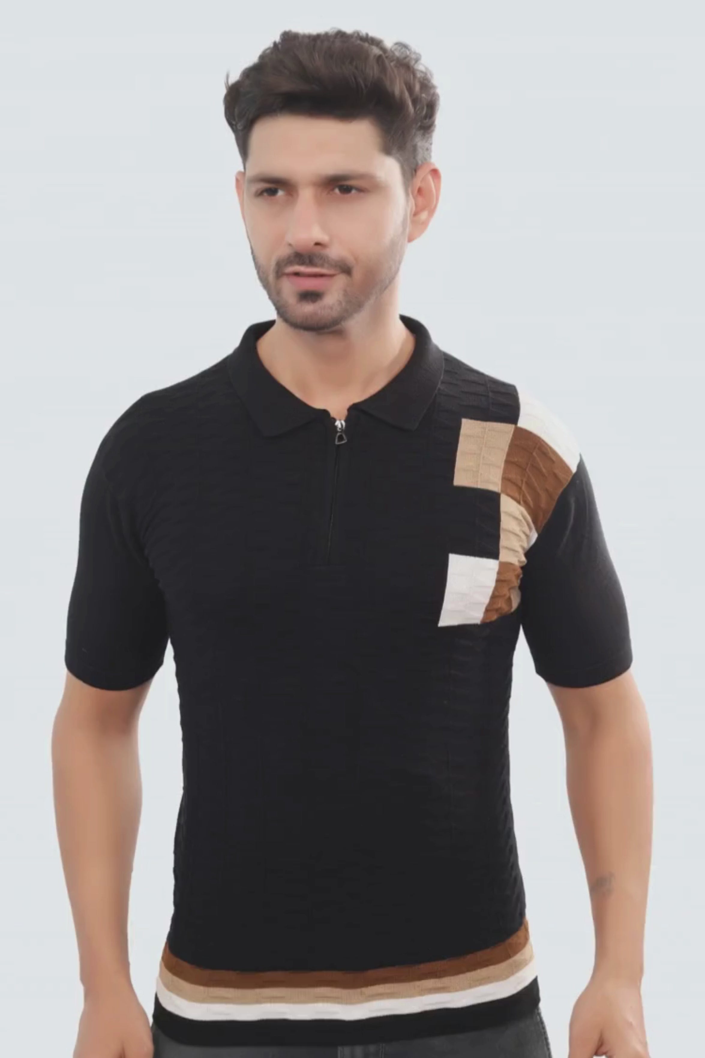 Man wearing a black polo shirt with color-blocked sleeves on a white background